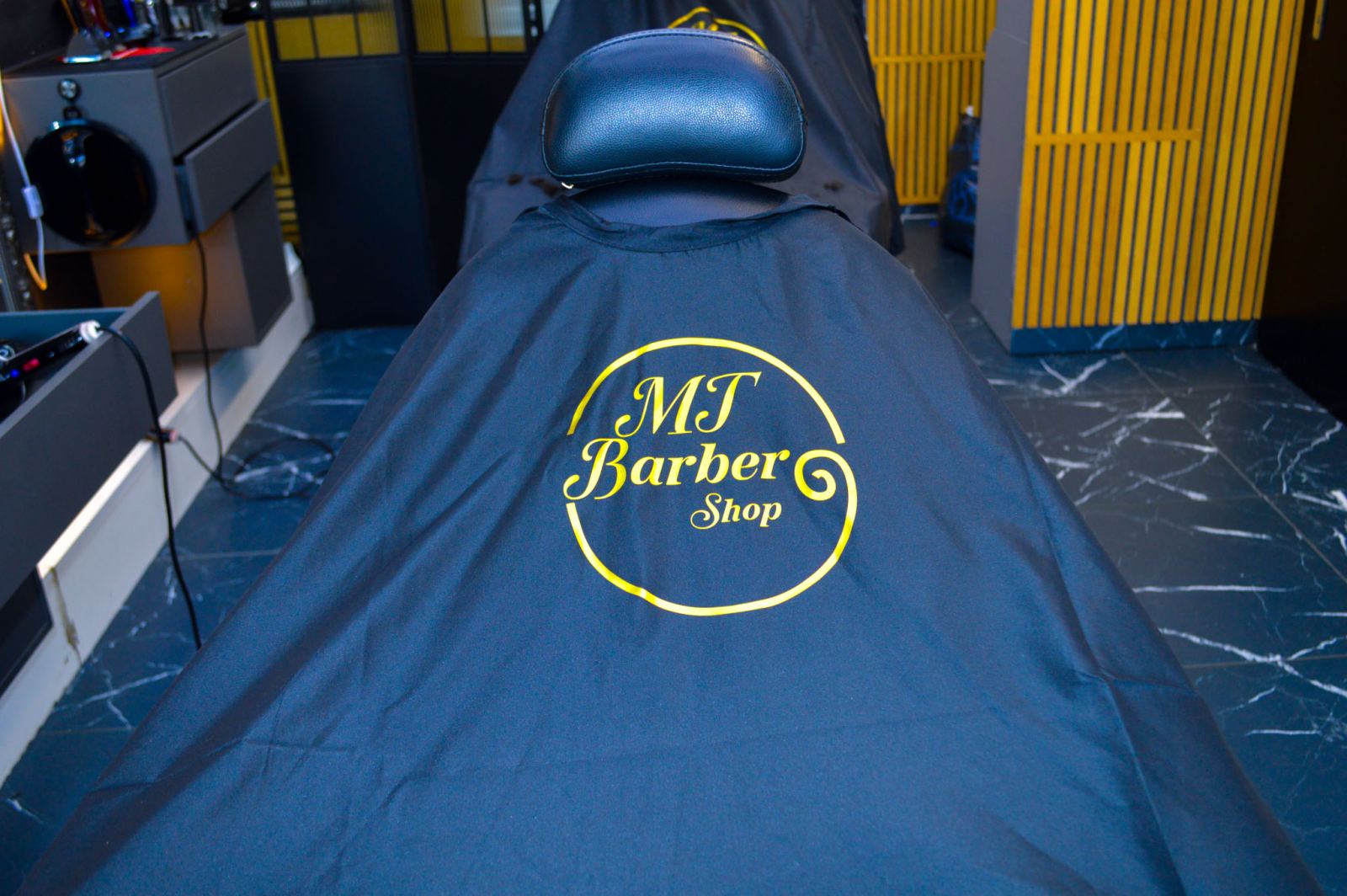 Fauteuil et cape au logo MT Barber Shop